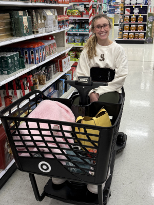 A young hip arthroscopy patient in an electric cart inside a store.